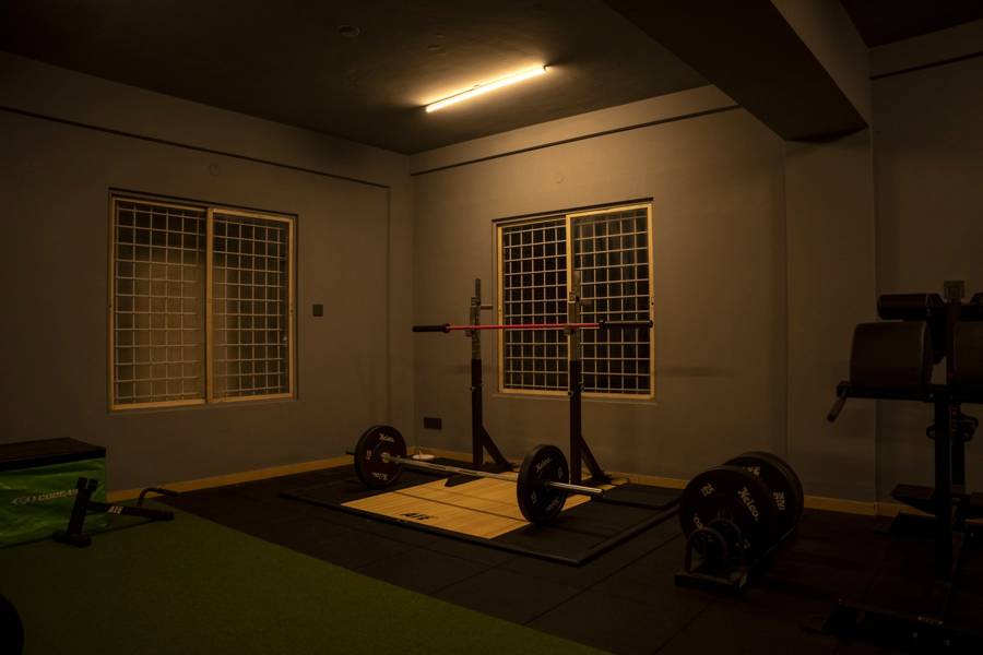 Olympic lifting platform with a loaded barbell and squat stand at UnReal Performance