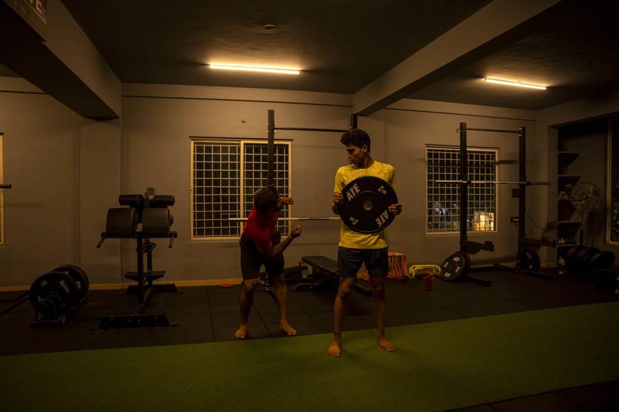 Coach and athlete performing weighted plate drills to build strength after injury