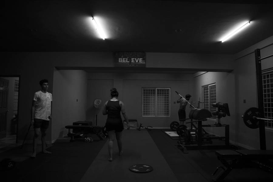 Group strength and conditioning session on the gym floor, black and white