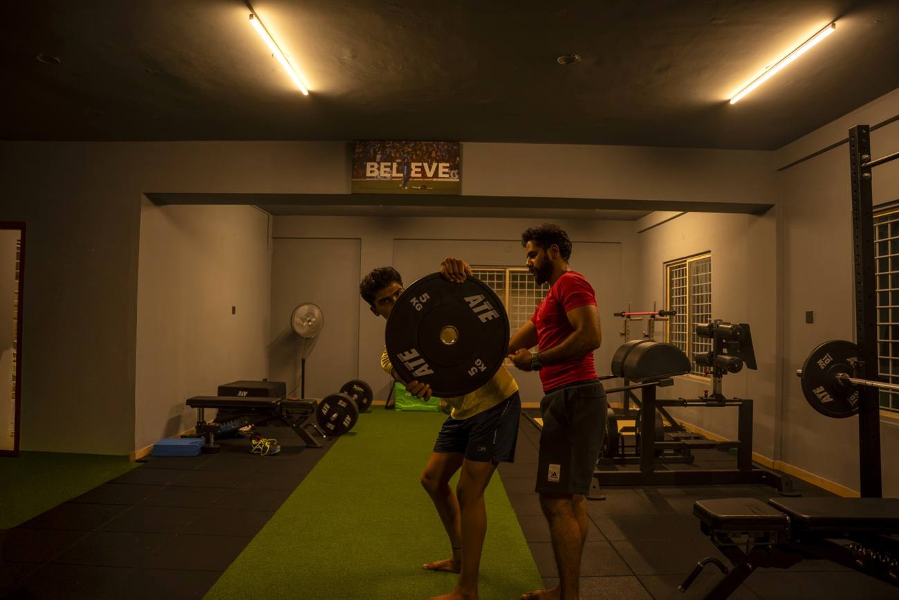 Coach guiding a weighted plate rotation to rebuild core strength and control