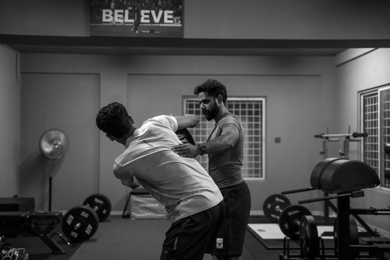Hands-on shoulder and upper back correction during a sports injury rehabilitation session
